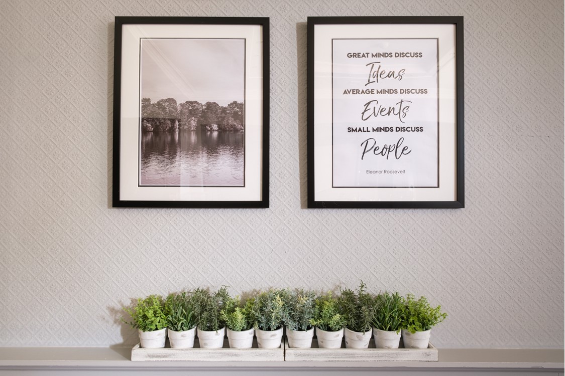 Wellbeing artwork above a row of small plants at Moor Hall